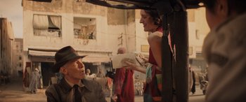 Movie still from “Indiana Jones and the Dial of Destiny” (2023), directed by James Mangold – A man and a woman standing next to each other on the street; Medium shot, Over the shoulder angle