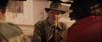 Movie still from “Indiana Jones and the Dial of Destiny” (2023), directed by James Mangold – An older man wearing a hat and a tie; Close Up shot, Over the shoulder angle