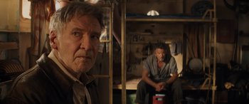 Movie still from “Indiana Jones and the Dial of Destiny” (2023), directed by James Mangold – Two men sitting on a bunk bed in a room; Close Up shot, Low angle