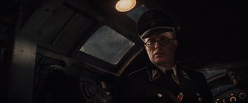 Movie still from “Indiana Jones and the Dial of Destiny” (2023), directed by James Mangold – A man in a military uniform is sitting in a vehicle; Close Up shot, Overhead angle