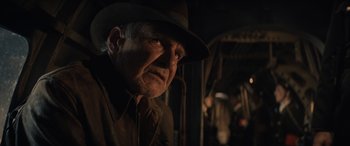 Movie still from “Indiana Jones and the Dial of Destiny” (2023), directed by James Mangold – An older man wearing a hat and a brown shirt; Close Up shot, Over the shoulder angle
