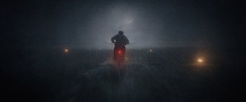 Movie still from “Indiana Jones and the Dial of Destiny” (2023), directed by James Mangold – A person riding a motorcycle in the rain; Extreme Wide shot, Low angle