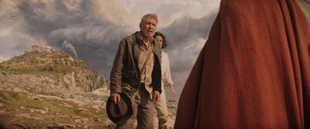 Movie still from “Indiana Jones and the Dial of Destiny” (2023), directed by James Mangold – A man and a woman are walking in a field; Medium shot, Low angle