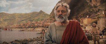 Movie still from “Indiana Jones and the Dial of Destiny” (2023), directed by James Mangold – An old man with a beard and a red scarf; Medium shot, Over the shoulder angle