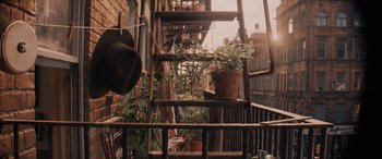 Movie still from “Indiana Jones and the Dial of Destiny” (2023), directed by James Mangold – A potted plant sitting on a ladder; Wide shot, Low angle