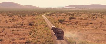 Movie still from “Indiana Jones and the Kingdom of the Crystal Skull” (2008), directed by Steven Spielberg – A train traveling down a dirt road in the middle of the desert; Extreme Wide shot, High angle