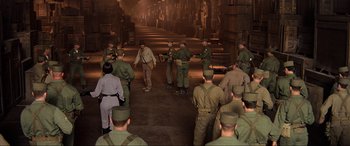 Movie still from “Indiana Jones and the Kingdom of the Crystal Skull” (2008), directed by Steven Spielberg – A group of men standing around in a room; Wide shot, High angle