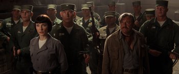 Movie still from “Indiana Jones and the Kingdom of the Crystal Skull” (2008), directed by Steven Spielberg – A group of men standing next to each other holding guns; Medium shot, Low angle