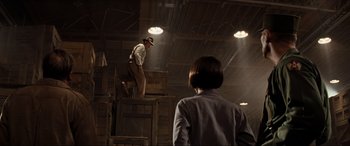 Movie still from “Indiana Jones and the Kingdom of the Crystal Skull” (2008), directed by Steven Spielberg – A man standing on top of a box while a woman looks on; Wide shot, Low angle