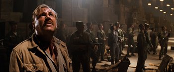 Movie still from “Indiana Jones and the Kingdom of the Crystal Skull” (2008), directed by Steven Spielberg – A group of men standing next to each other in a room; Medium shot, Low angle