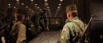 Movie still from “Indiana Jones and the Kingdom of the Crystal Skull” (2008), directed by Steven Spielberg – A group of men sitting on top of a wooden table; Wide shot, Low angle