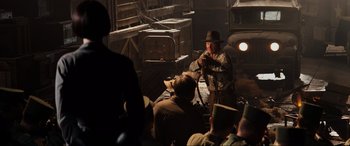 Movie still from “Indiana Jones and the Kingdom of the Crystal Skull” (2008), directed by Steven Spielberg – A man in a hat is holding a microphone; Wide shot, Over the shoulder angle