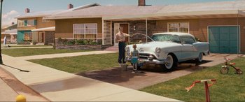 Movie still from “Indiana Jones and the Kingdom of the Crystal Skull” (2008), directed by Steven Spielberg – A man and a child washing a car in a driveway; Extreme Wide shot, High angle