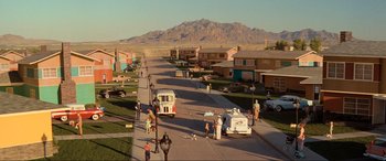 Movie still from “Indiana Jones and the Kingdom of the Crystal Skull” (2008), directed by Steven Spielberg – People are walking down the street in a residential area; Extreme Wide shot, High angle