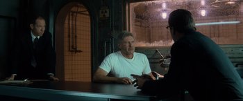 Movie still from “Indiana Jones and the Kingdom of the Crystal Skull” (2008), directed by Steven Spielberg – A man sitting in front of another man at a table; Medium shot, Over the shoulder angle