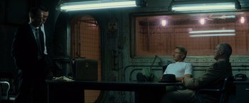 Movie still from “Indiana Jones and the Kingdom of the Crystal Skull” (2008), directed by Steven Spielberg – A man sitting at a desk in a room; Wide shot, High angle