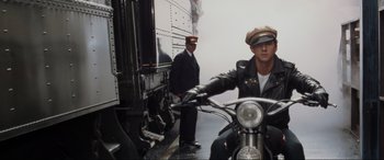 Movie still from “Indiana Jones and the Kingdom of the Crystal Skull” (2008), directed by Steven Spielberg – A man on a motorcycle in front of a train; Medium shot, Low angle