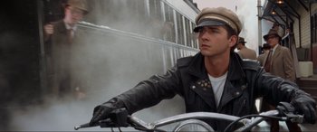Movie still from “Indiana Jones and the Kingdom of the Crystal Skull” (2008), directed by Steven Spielberg – A man riding a bike wearing a leather jacket and hat; Close Up shot, Low angle