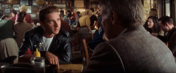 Movie still from “Indiana Jones and the Kingdom of the Crystal Skull” (2008), directed by Steven Spielberg – A man sitting at a table in front of another man; Close Up shot, Over the shoulder angle