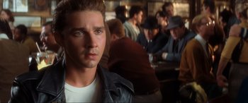 Movie still from “Indiana Jones and the Kingdom of the Crystal Skull” (2008), directed by Steven Spielberg – A man in a leather jacket is in front of a group of people; Close Up shot, Over the shoulder angle