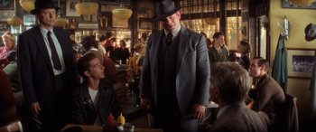 Movie still from “Indiana Jones and the Kingdom of the Crystal Skull” (2008), directed by Steven Spielberg – A group of people sitting at a table in a restaurant; Medium shot, Over the shoulder angle