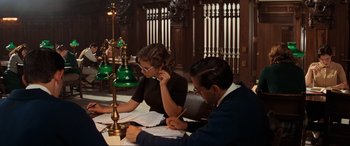 Movie still from “Indiana Jones and the Kingdom of the Crystal Skull” (2008), directed by Steven Spielberg – A man and a woman sitting at a table with papers; Medium shot, High angle