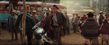 Movie still from “Indiana Jones and the Kingdom of the Crystal Skull” (2008), directed by Steven Spielberg – An old man in a hat is standing next to a motorcycle; Wide shot, Over the shoulder angle