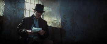 Movie still from “Indiana Jones and the Kingdom of the Crystal Skull” (2008), directed by Steven Spielberg – An older man in a hat is holding an envelope; Close Up shot, Over the shoulder angle