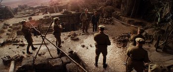 Movie still from “Indiana Jones and the Kingdom of the Crystal Skull” (2008), directed by Steven Spielberg – A group of men standing in a dirt field; Wide shot, High angle
