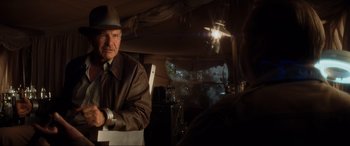 Movie still from “Indiana Jones and the Kingdom of the Crystal Skull” (2008), directed by Steven Spielberg – An older man wearing a brown jacket and a hat; Medium shot, Over the shoulder angle