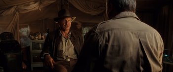 Movie still from “Indiana Jones and the Kingdom of the Crystal Skull” (2008), directed by Steven Spielberg – A man wearing a hat sitting next to another man; Medium shot, Over the shoulder angle