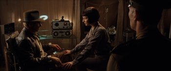 Movie still from “Indiana Jones and the Kingdom of the Crystal Skull” (2008), directed by Steven Spielberg – A woman sitting in front of an old radio; Medium shot, Over the shoulder angle