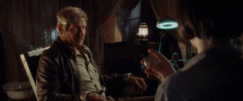 Movie still from “Indiana Jones and the Kingdom of the Crystal Skull” (2008), directed by Steven Spielberg – A man sitting next to a woman in front of a lamp; Medium shot, Over the shoulder angle