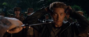Movie still from “Indiana Jones and the Kingdom of the Crystal Skull” (2008), directed by Steven Spielberg – A young man holding a sword in a forest; Close Up shot, Over the shoulder angle