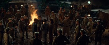 Movie still from “Indiana Jones and the Kingdom of the Crystal Skull” (2008), directed by Steven Spielberg – A group of people in uniform standing around a fire; Wide shot, High angle
