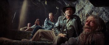 Movie still from “Indiana Jones and the Kingdom of the Crystal Skull” (2008), directed by Steven Spielberg – A group of people sitting in a cave; Wide shot, Low angle