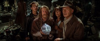 Movie still from “Indiana Jones and the Kingdom of the Crystal Skull” (2008), directed by Steven Spielberg – A group of people standing next to each other holding a skull; Close Up shot, Over the shoulder angle