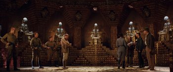 Movie still from “Indiana Jones and the Kingdom of the Crystal Skull” (2008), directed by Steven Spielberg – A group of people standing in front of a stage; Wide shot, Low angle