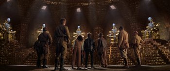 Movie still from “Indiana Jones and the Kingdom of the Crystal Skull” (2008), directed by Steven Spielberg – A group of people standing in front of a wall of books; Wide shot, Low angle