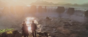 Movie still from “Indiana Jones and the Kingdom of the Crystal Skull” (2008), directed by Steven Spielberg – Two people standing on a rocky shore near a body of water; Extreme Wide shot, High angle