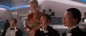 Movie still from “Indiana Jones and the Temple of Doom” (1984), directed by Steven Spielberg – A man and a woman are dressed up for a party; Medium shot, Low angle