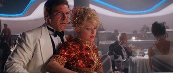 Movie still from “Indiana Jones and the Temple of Doom” (1984), directed by Steven Spielberg – A man and a woman in formal wear looking at a laptop; Medium shot, Low angle