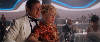 Movie still from “Indiana Jones and the Temple of Doom” (1984), directed by Steven Spielberg – A man and a woman in formal wear standing next to each other; Medium shot, Low angle