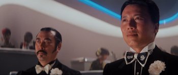 Movie still from “Indiana Jones and the Temple of Doom” (1984), directed by Steven Spielberg – A man in a suit and tie standing next to another man in a suit and tie; Close Up shot, Low angle