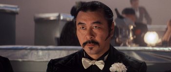 Movie still from “Indiana Jones and the Temple of Doom” (1984), directed by Steven Spielberg – A person wearing a bow tie; Close Up shot, Low angle