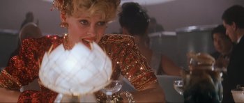 Movie still from “Indiana Jones and the Temple of Doom” (1984), directed by Steven Spielberg – A person holding a drink in their hand; Close Up shot, Over the shoulder angle