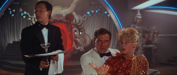 Movie still from “Indiana Jones and the Temple of Doom” (1984), directed by Steven Spielberg – A group of people standing next to each other in a room; Medium shot, Over the shoulder angle