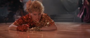Movie still from “Indiana Jones and the Temple of Doom” (1984), directed by Steven Spielberg – A woman in a red and gold dress laying on the floor; Close Up shot, High angle