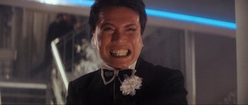 Movie still from “Indiana Jones and the Temple of Doom” (1984), directed by Steven Spielberg – A person wearing a suit and tie; Close Up shot, Low angle