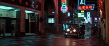 Movie still from “Indiana Jones and the Temple of Doom” (1984), directed by Steven Spielberg – A car is driving down the street at night; Extreme Wide shot, High angle